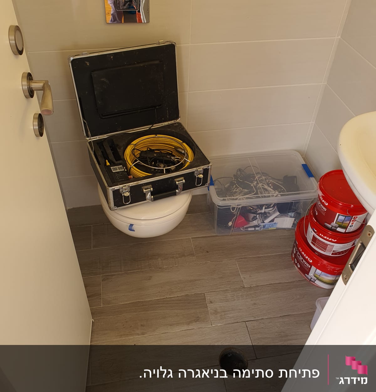 תיק כלים פתוח עם כבל צהוב על אסלה